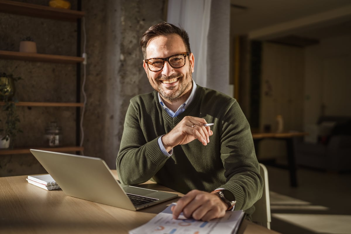 Experienced language coach with glasses working in a bright home office